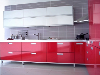 close up shot of a red modern kitchen with cabinet and drawers